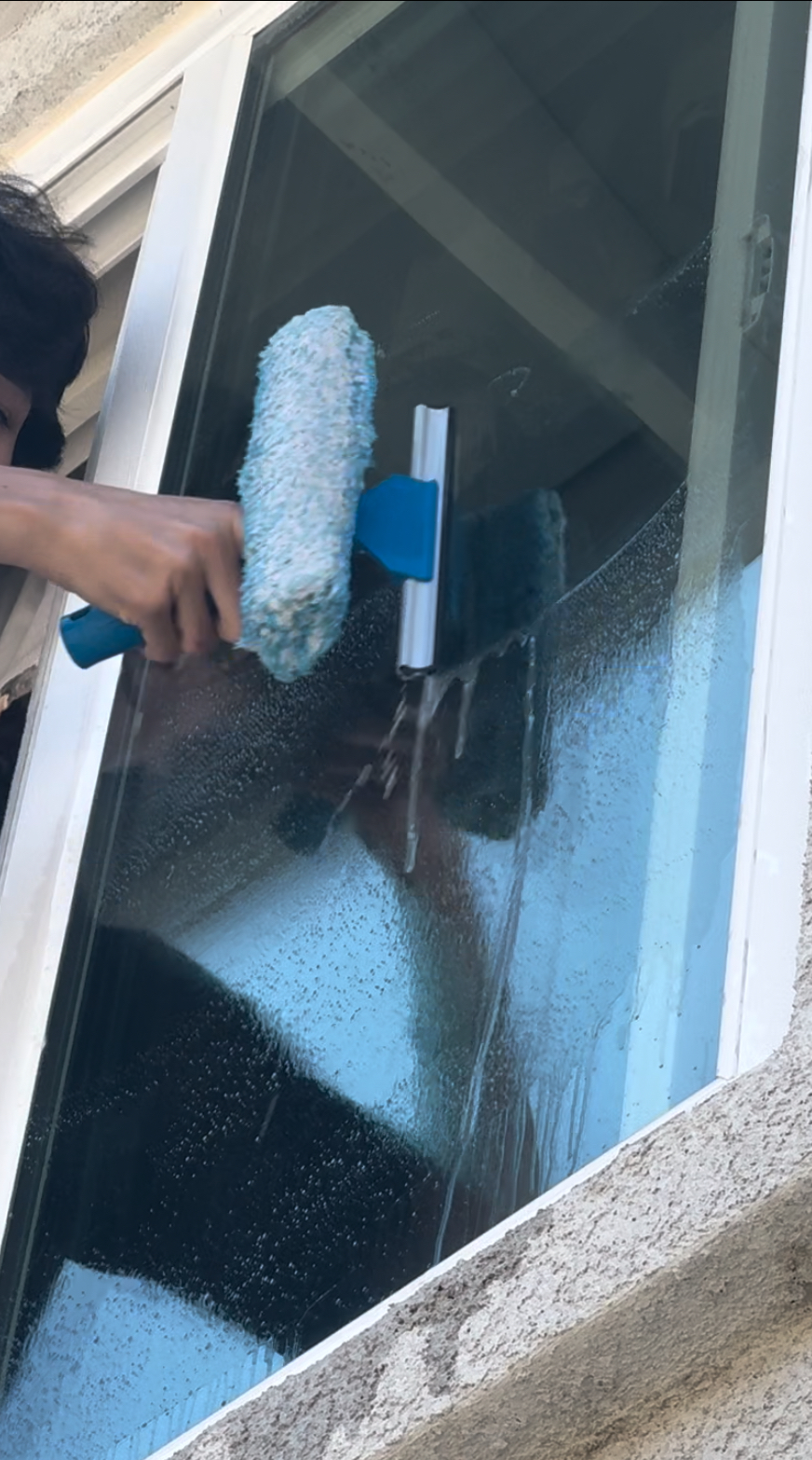 Professional window cleaning process - detailed squeegee work removing dirt and grime